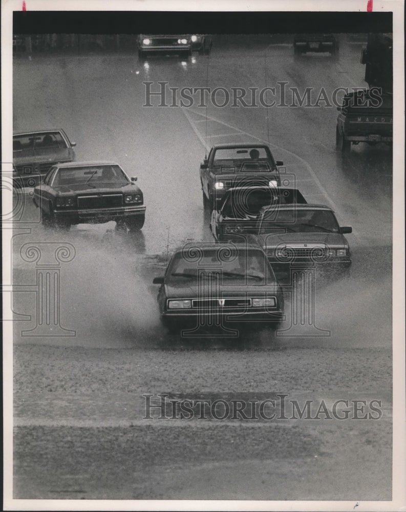 1988, Cars splash through water on flooded road, Birmingham, Alabama - Historic Images