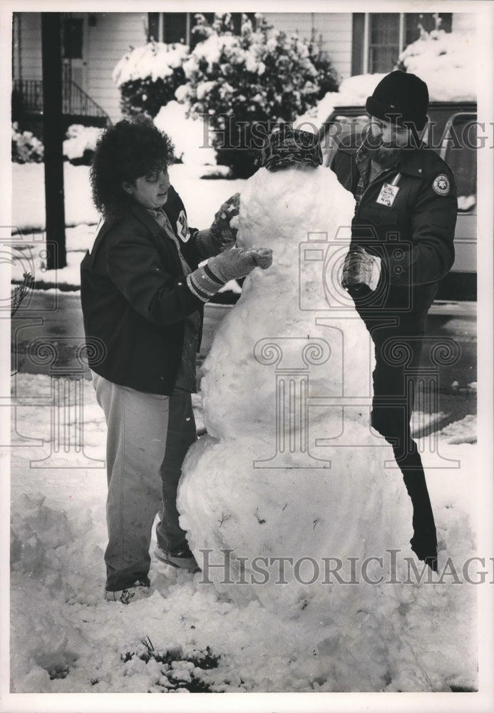 1987, Beth King, Ricky King of East Lake making Snowman in Yard - Historic Images