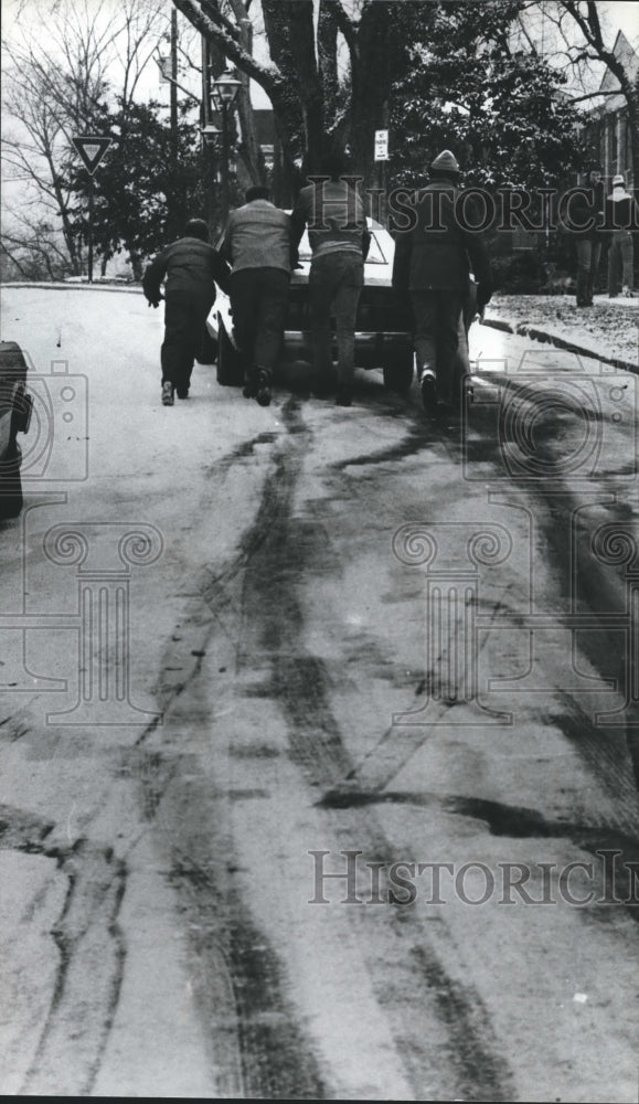 1982 Press Photo Unidentified folks push car up icy Highland Avenue, Alabama - Historic Images