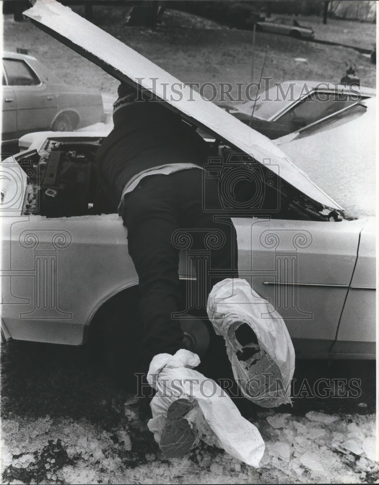 1982, Malcolm Smith trying to get his car started in the cold weather - Historic Images