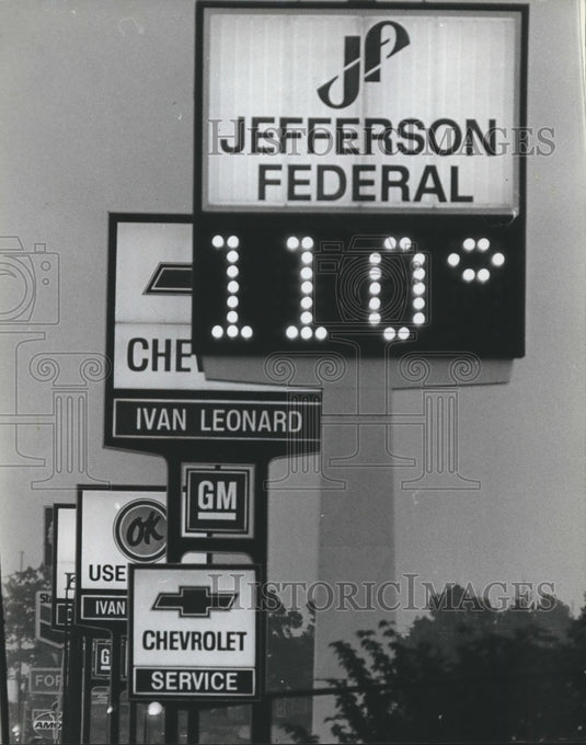 1980, Sign in midst of auto dealers, shows it's 110 outside, Alabama - Historic Images