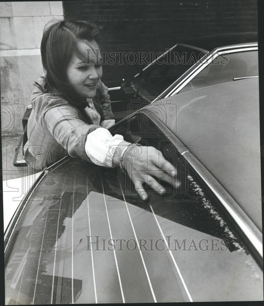 1980 Marilyn Turner, brushes snow off car in Birmingham, Alabama - Historic Images