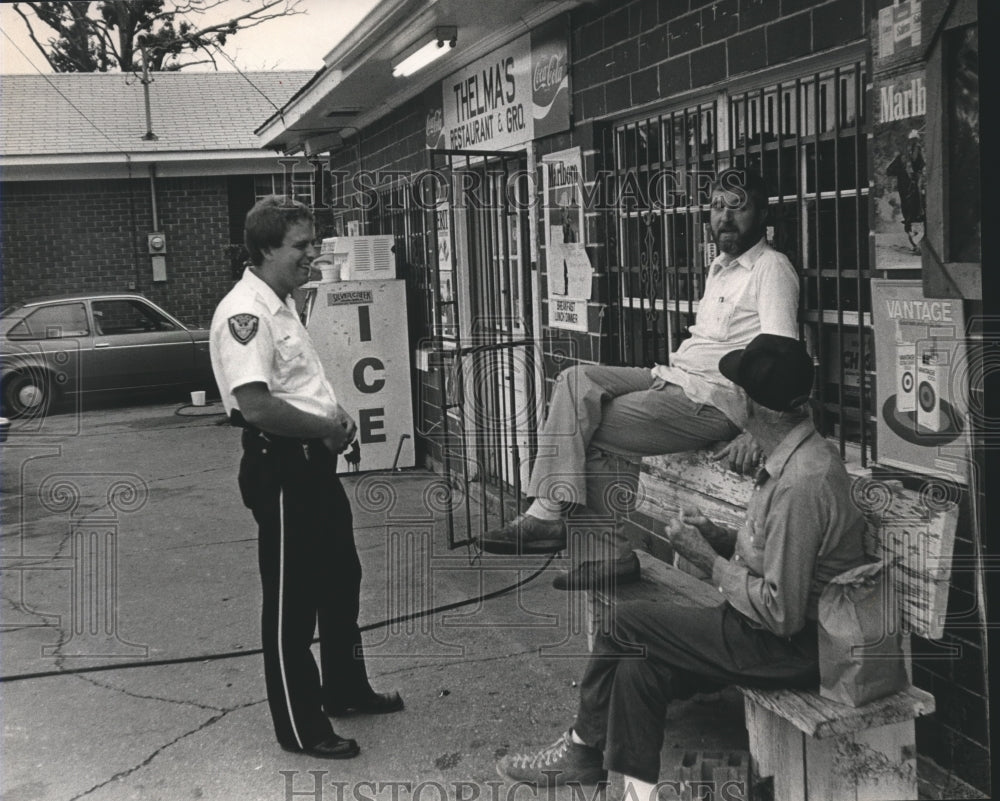 1983, Police Chief Anderson chats with merchant Wayne Smith, Others - Historic Images