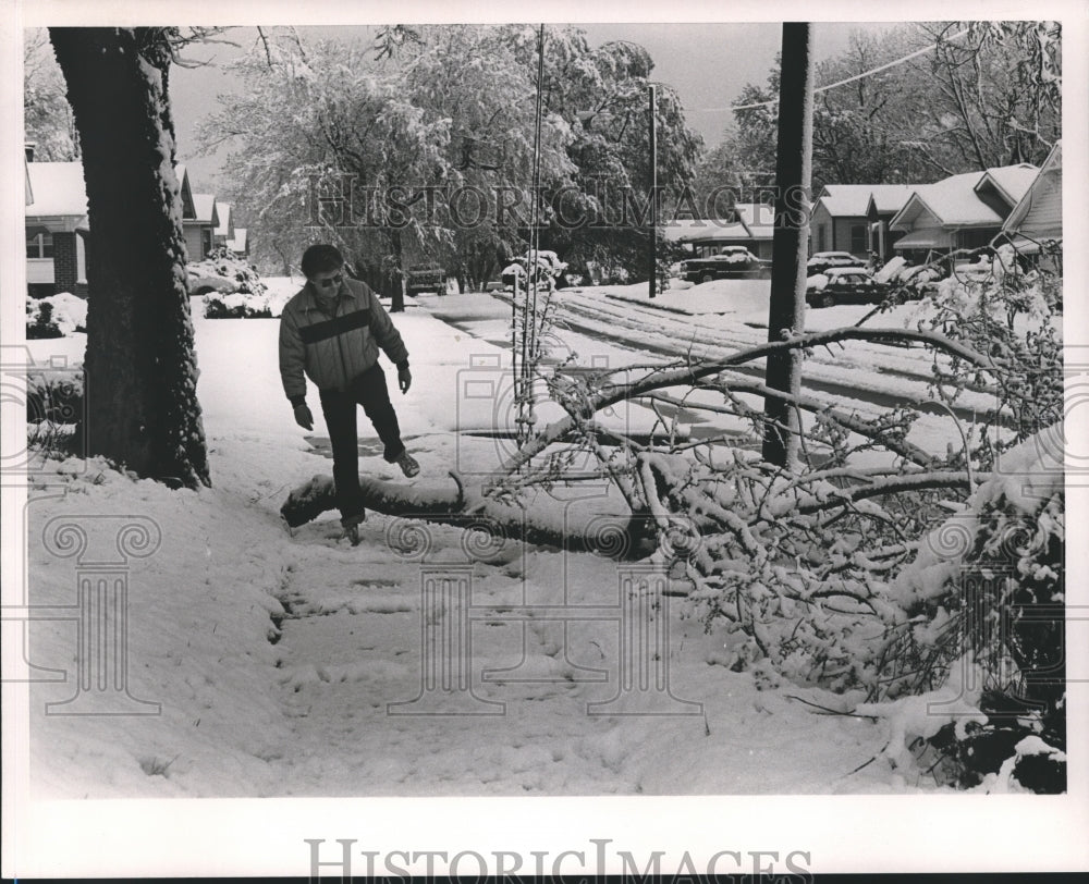 1987 Press Photo Bob Nance steps over downed tree on Fulton Avenue - abna17635 - Historic Images