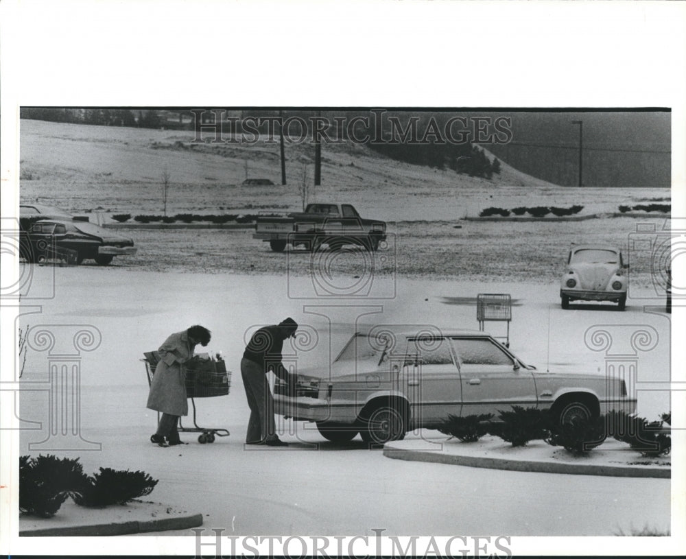 1982 Press Photo People load groceries into car in snowy parking lot at mall - Historic Images