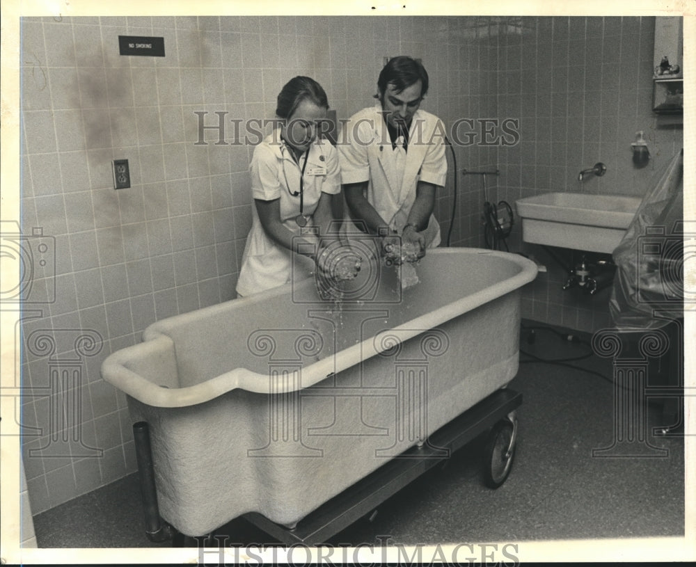 1980, Two medical employees hold ice at hospital bathtub - abna17668 - Historic Images