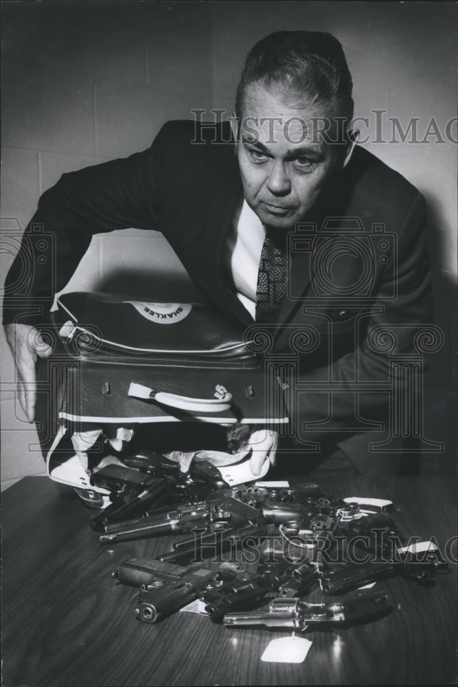 1973, Tom Ward, Fairfield Police Chief with bag of guns, Alabama - Historic Images