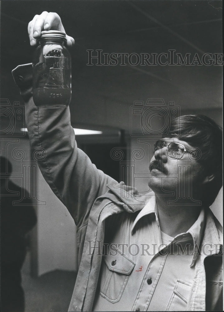 1979, Richard Gardner examines jar containing brackish water - Historic Images