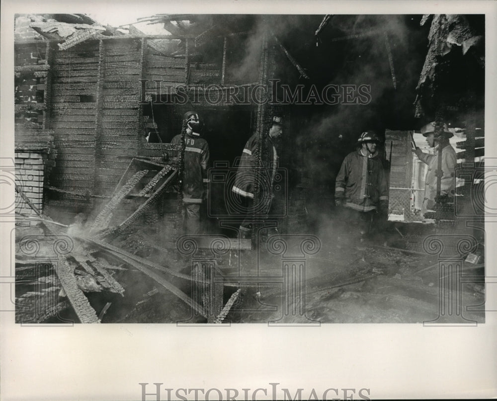 1988 Press Photo Fire at Avenue C and 31st Street, Firemen check damage - Historic Images