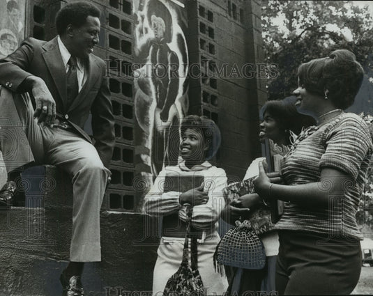1973, Dr. Clyde Williams talks to students at Miles College by wall - Historic Images
