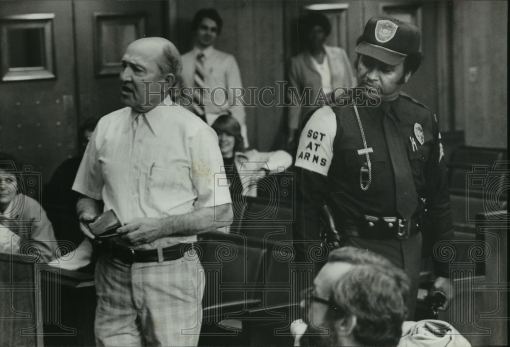 1982, R.L. Webb holds pistol removed from Reynolds at City Council - Historic Images