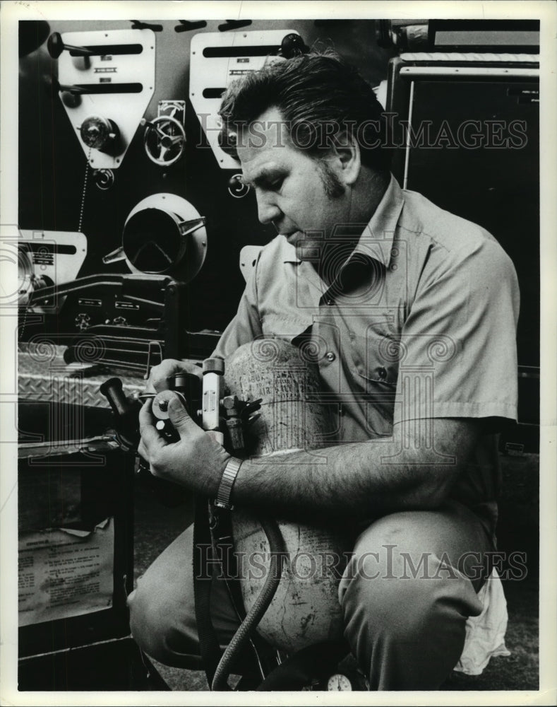 1978, William Brewer, firefighter, checks air masks, tanks, Alabama - Historic Images