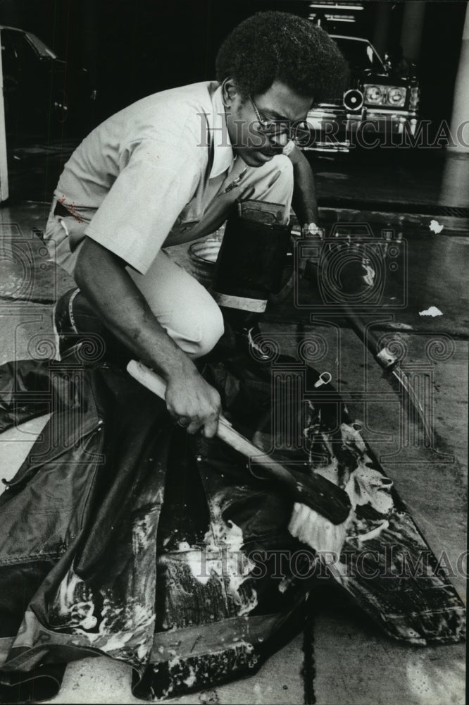 1978, Firefighter Jackie Barton scrubbing coat, Birmingham - Historic Images