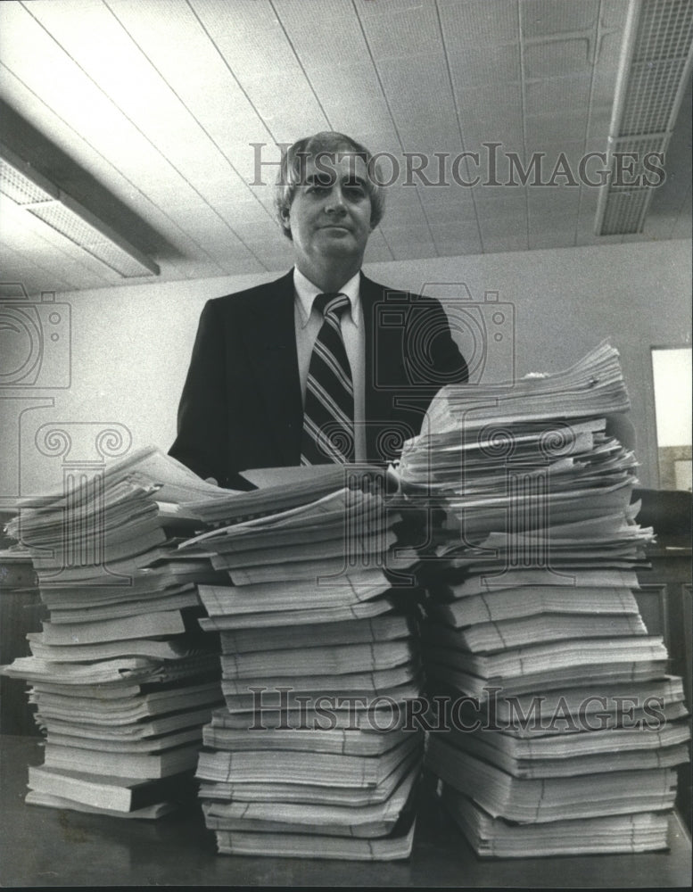 1979 Documents piled high in front of PSC staffer Carl Evans - Historic Images