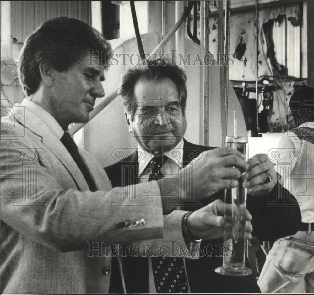 1980 Jim Floyd shows alcohol fuel to Dr. Richard Blaser - Historic Images