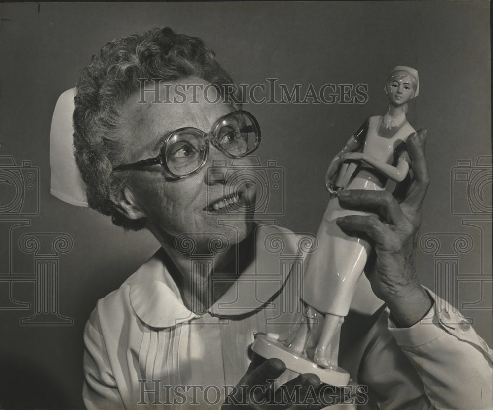 1983 Nurse Josephene Early holds Florence Nightingale statue - Historic Images