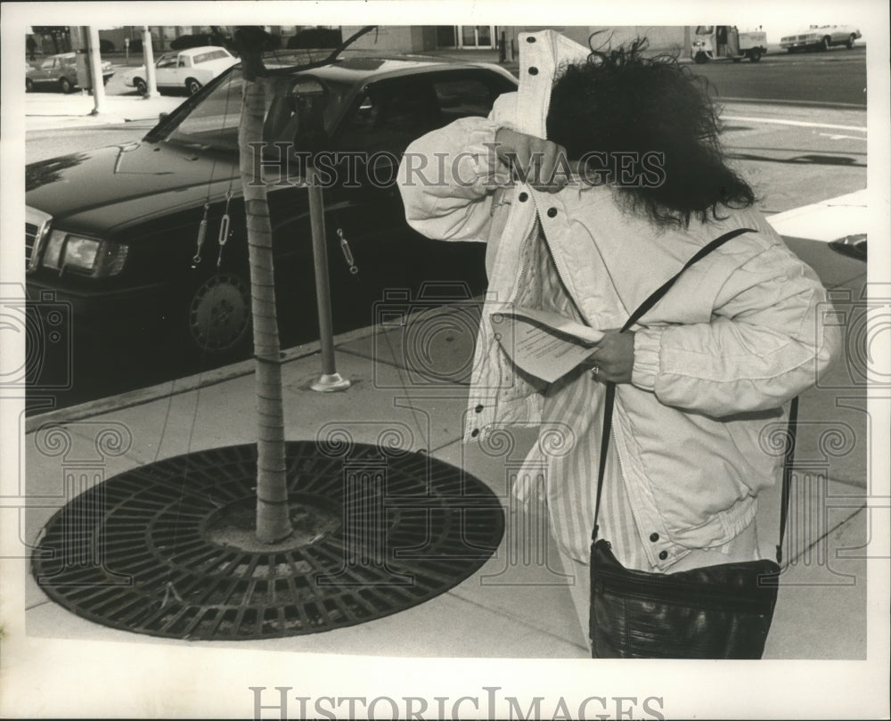 1987 Dawn Easley covers her face with jacket - Historic Images