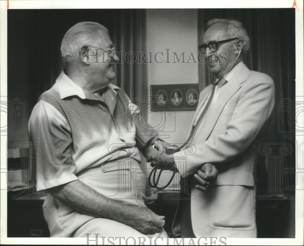 1981 Nurse Frank Dulaney takes Blood Pressure for Dr. Ben Carraway - Historic Images