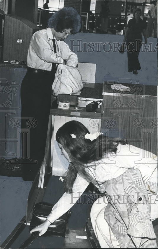 1977, Airport security guard checking carryon luggage, Birmingham - Historic Images