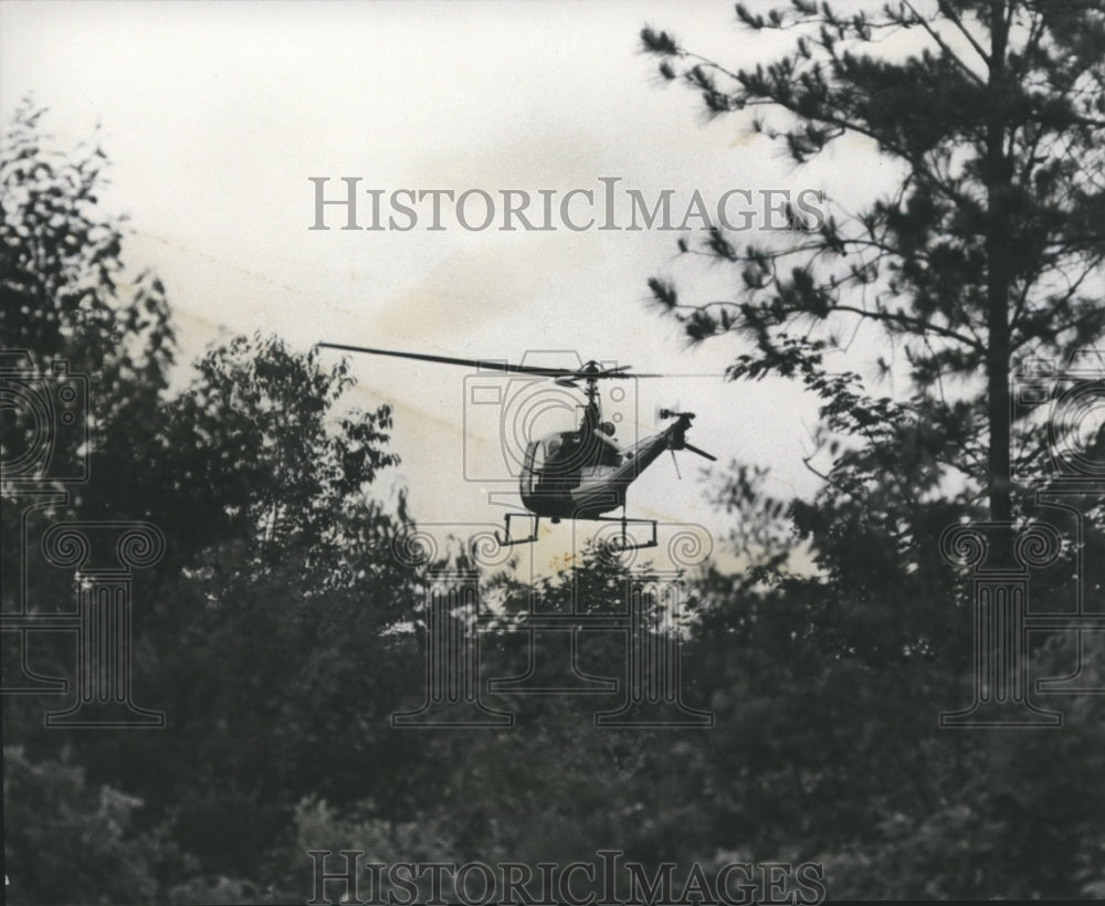 1975 Press Photo Helicopter searches thickly wooded area where bandits fled - Historic Images
