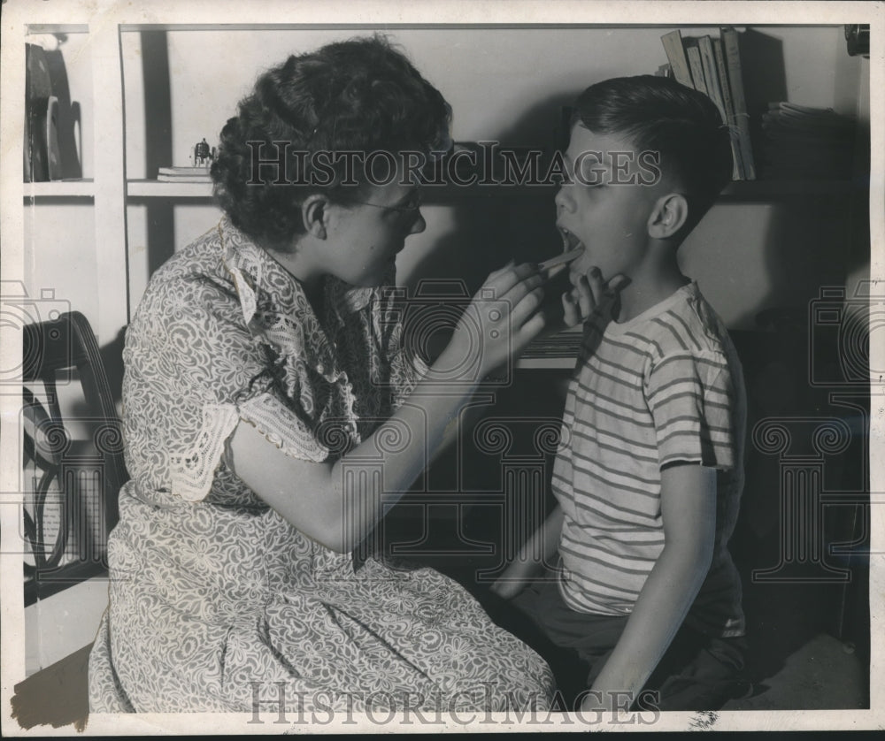 1948 Miss Coffman checks child&#39;s throat at speech clinic, Tuscaloosa - Historic Images