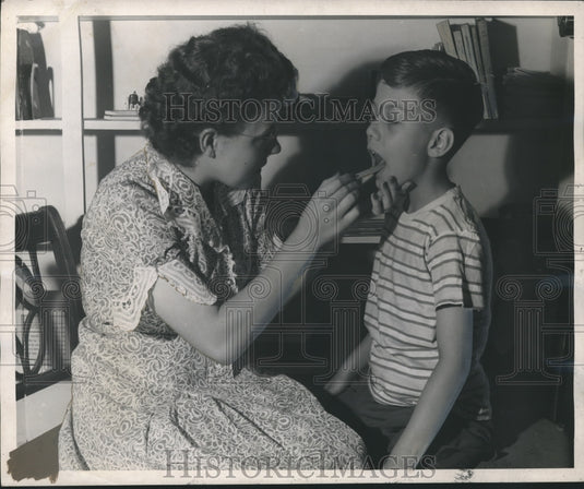 1948 Miss Coffman checks child's throat at speech clinic, Tuscaloosa - Historic Images
