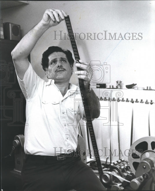 1981, Film Maker Abe Fawal examines raw film on Spool - abna30388 - Historic Images