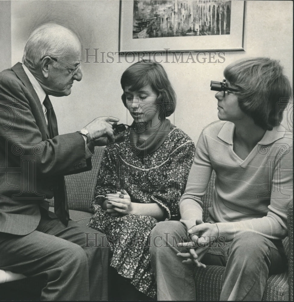 1977, optometrist, Dr. Will Feinbloom shows off telescopic glasses - Historic Images