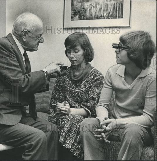 1977, optometrist, Dr. Will Feinbloom shows off telescopic glasses - Historic Images