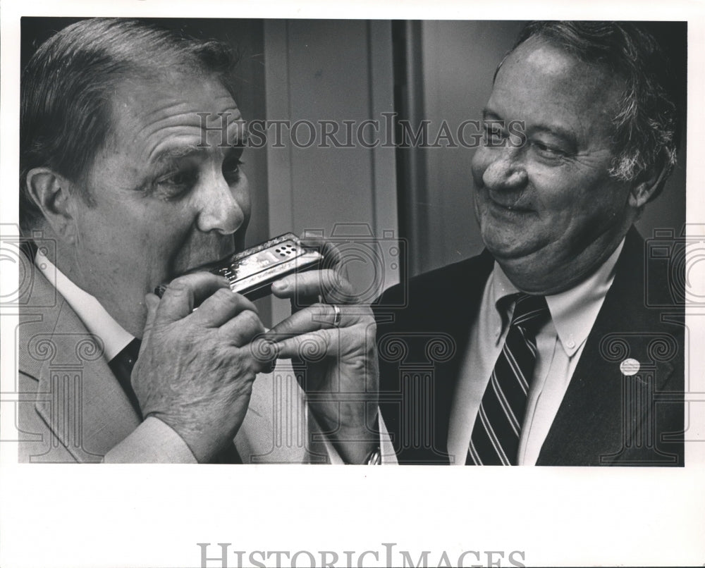 1988, Jack F. Douglas entertains Ed Grouby with mouth organ, politics - Historic Images