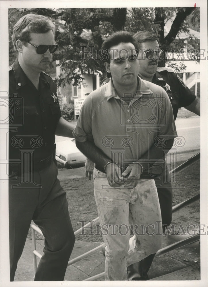 1989, Mark Allen Jenkins in handcuffs escorted by police officers - Historic Images