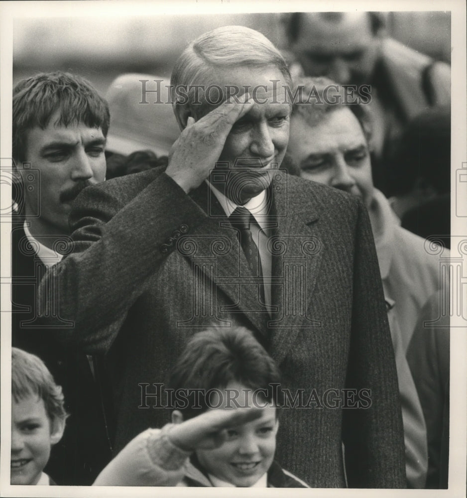 1987 Hunt, with others, saluting Military in parade, Alabama - Historic Images