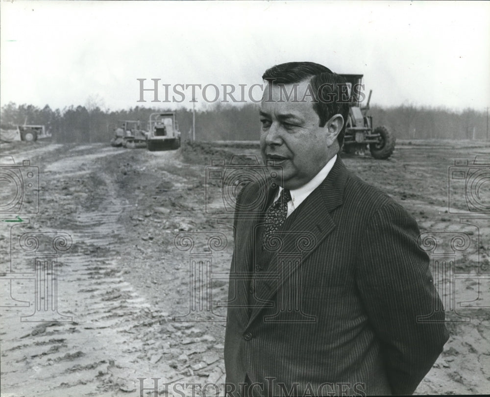 1982, Olin B. King of SCI Systems stands among heavy dirt movers - Historic Images