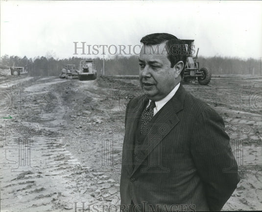 1982, Olin B. King of SCI Systems stands among heavy dirt movers - Historic Images