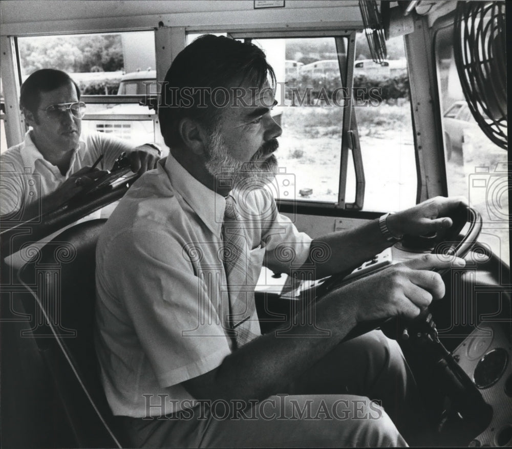 1981 Doctor John (Jack) Hunt driving school bus with Kenneth Karr - Historic Images