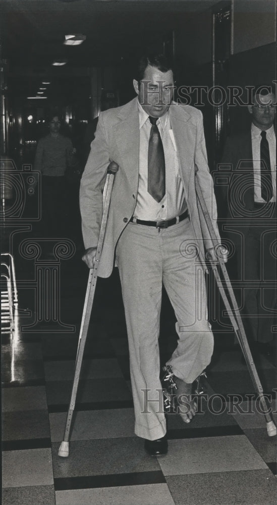 1983, Larry Joe Jordan walks in hallway using crutches - abna35102 - Historic Images