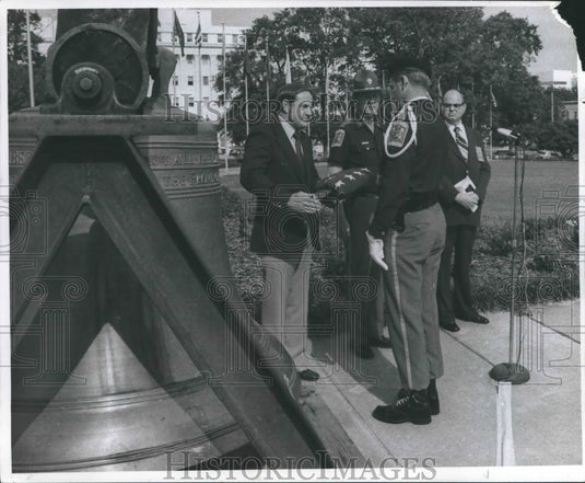 1980 Honor Guard member hands Alabama Governor Fob James a flag - Historic Images