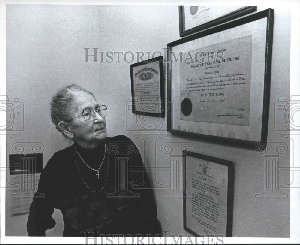 1993, Myrtle Lowery, 97, looks at her nursing certificates, Alabama - Historic Images