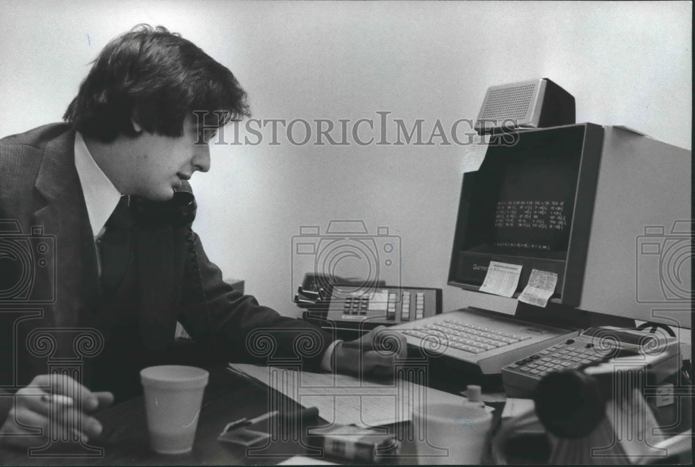1980 James R. Justice, banker, checks stock prices, Birmingham - Historic Images