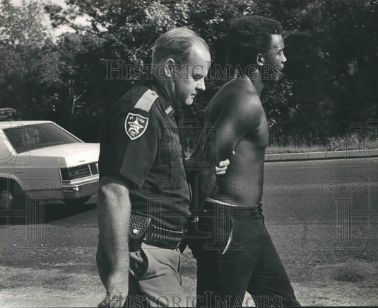 1984, Sylvester Jones escorted by Deputy Sharp in St. Clair County - Historic Images