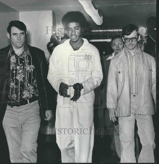 1977, Jerry Lee Jones escorted by Sergeant B. R. Stephens in hallway - Historic Images