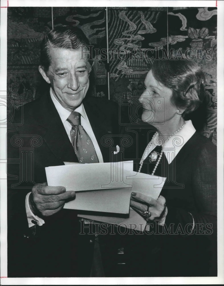 1975 Mr. and Mrs. Lathrop are helping with festivities for Party - Historic Images