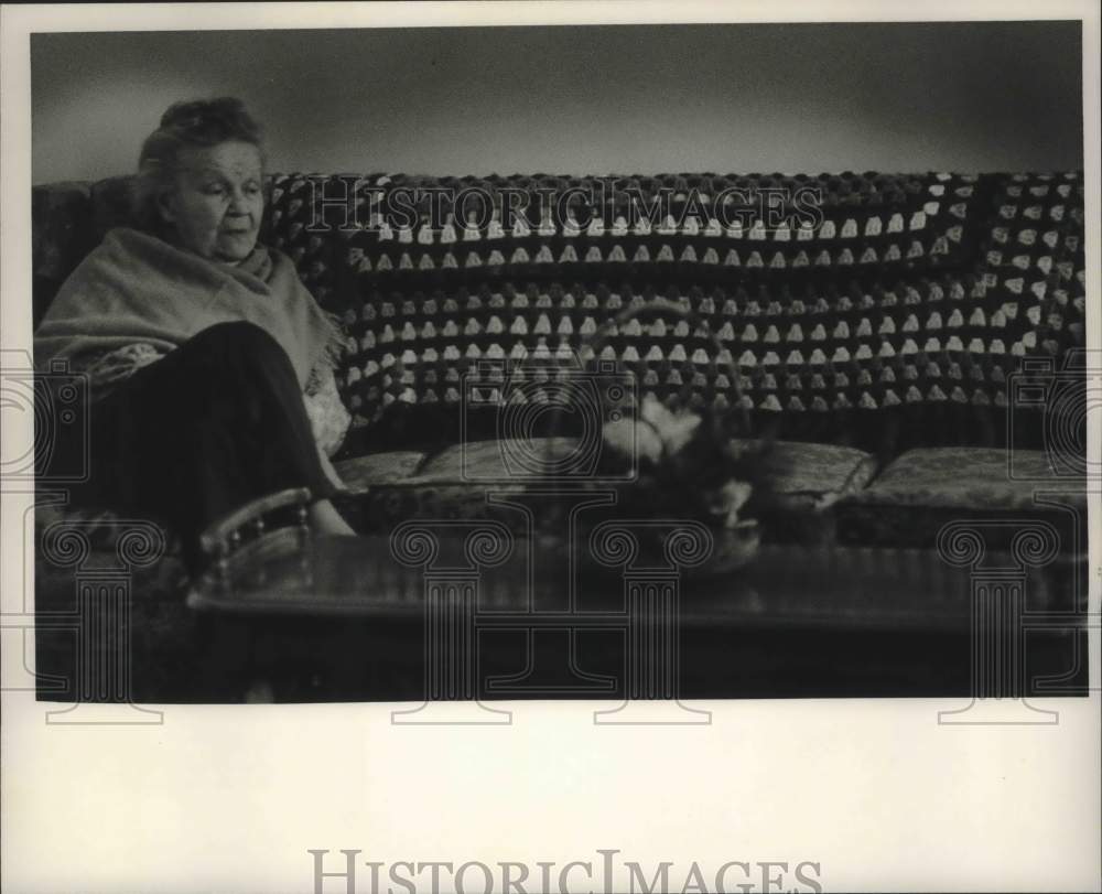 Press Photo woman sits on couch at Fairfield Nursing Home, Ethyland address - Historic Images