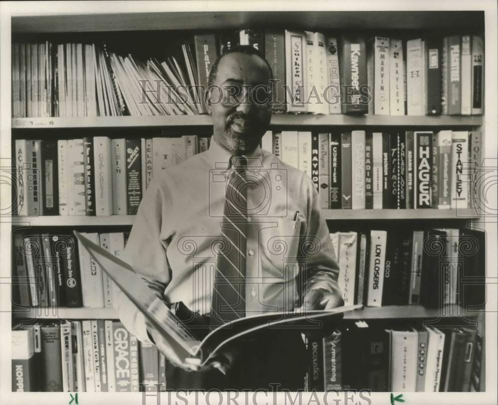 1989 Press Photo Ken Owens standing in library before books - abna37782 - Historic Images