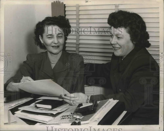 1948, Ida Rosenthan, Nellie Mobley looking over papers and books - Historic Images