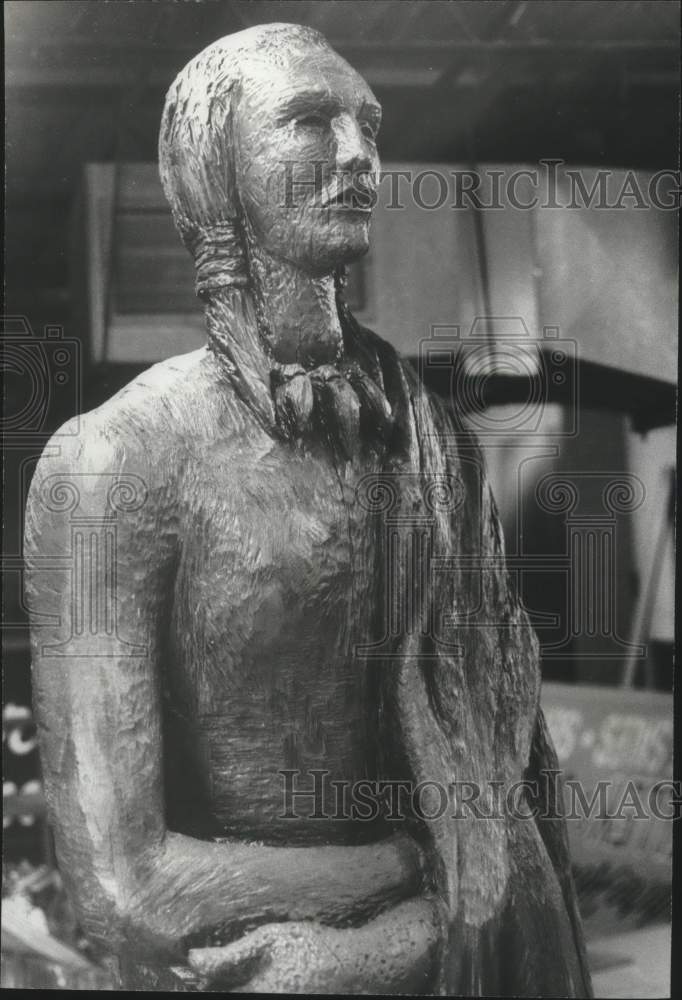 1974, Sculpture by Bill Sharpton of Indian carved from sweet gum log - Historic Images