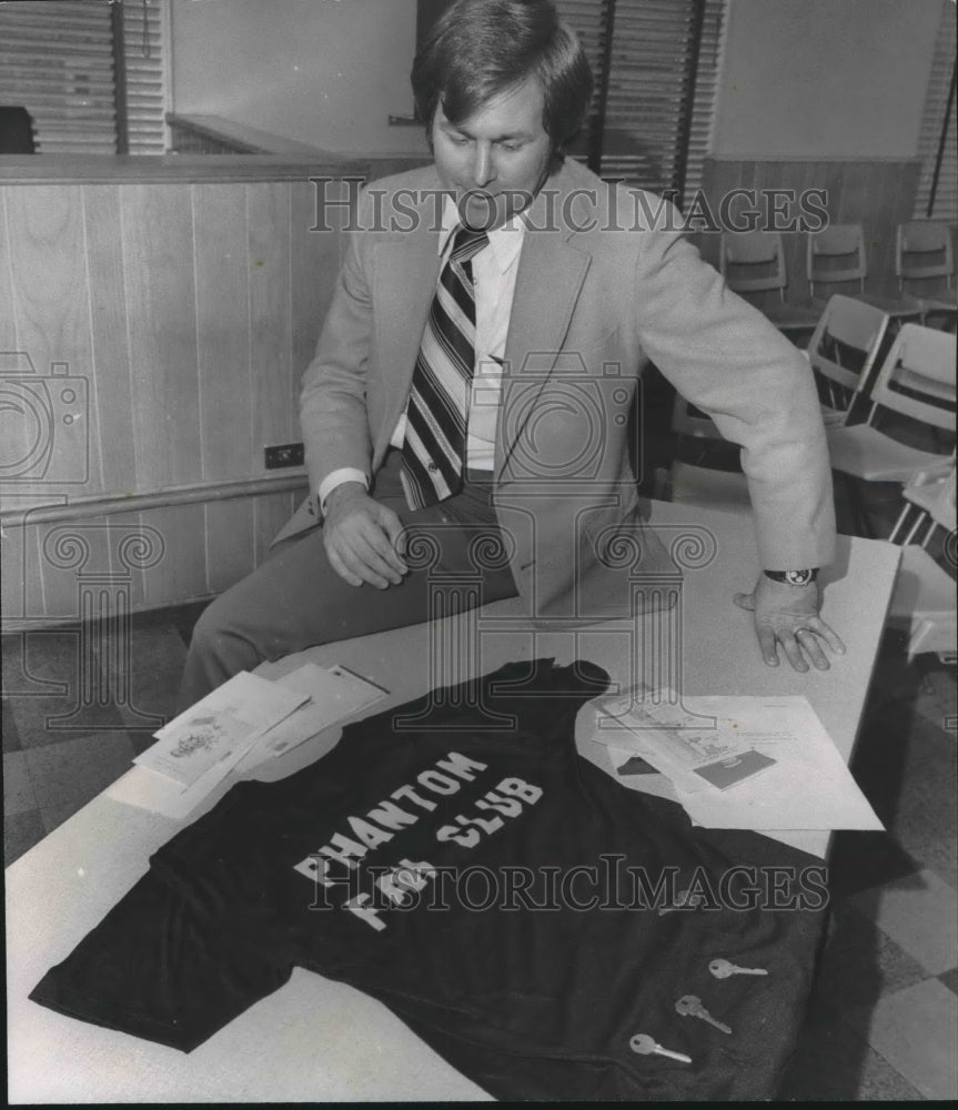 1978, Homewood Police Chief Jerry Haynes looks at Phantom Club Shirt - Historic Images