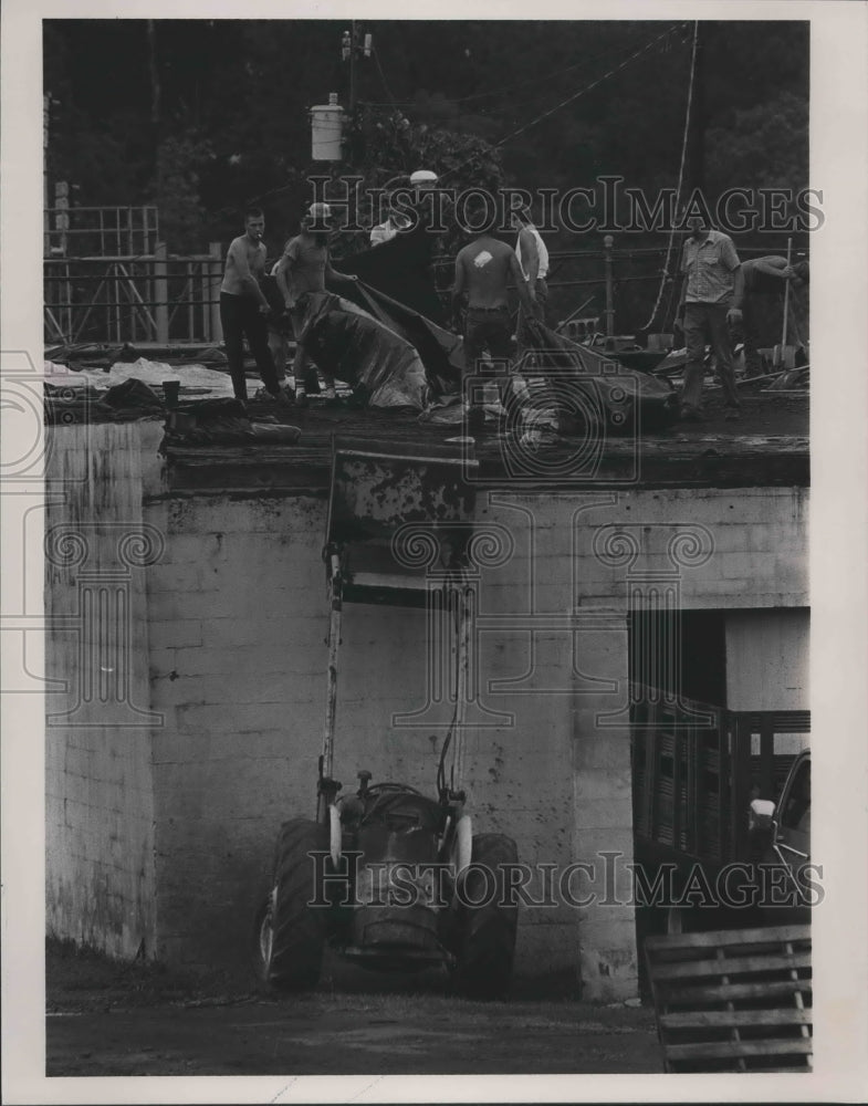 1985 Workers clean up tornado damage on the roof in Parrish, Alabama - Historic Images