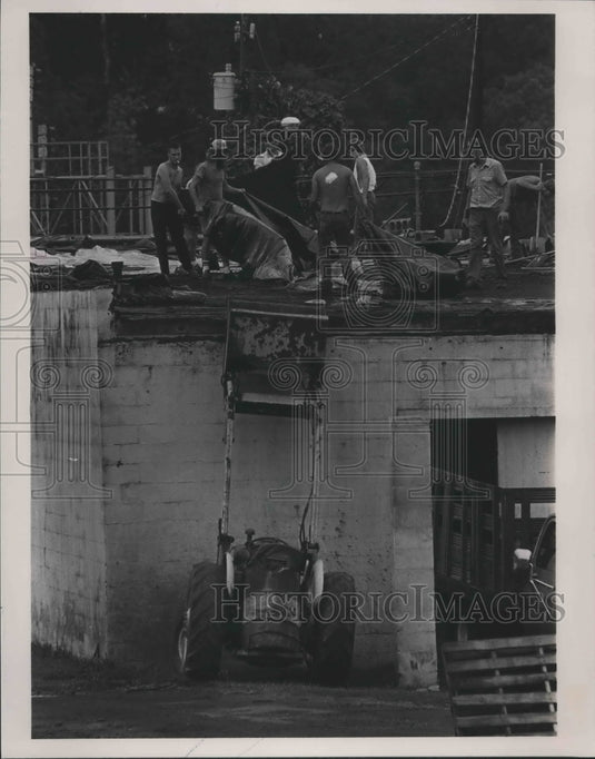1985 Workers clean up tornado damage on the roof in Parrish, Alabama - Historic Images