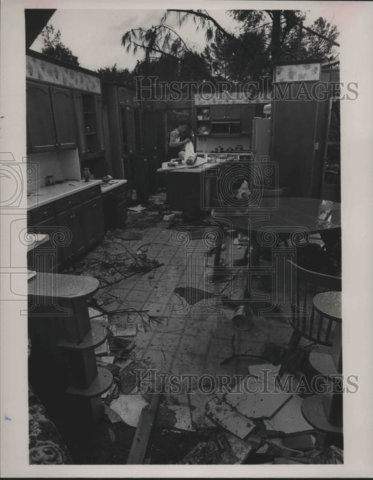 1985, Bobby Gean Cates helps woman after Tornado Damage in Alabama - Historic Images